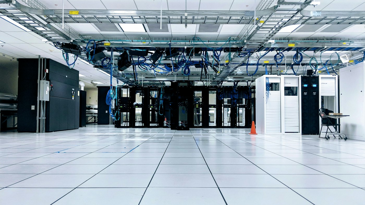 Bright corridor between racks with overhead cable trays